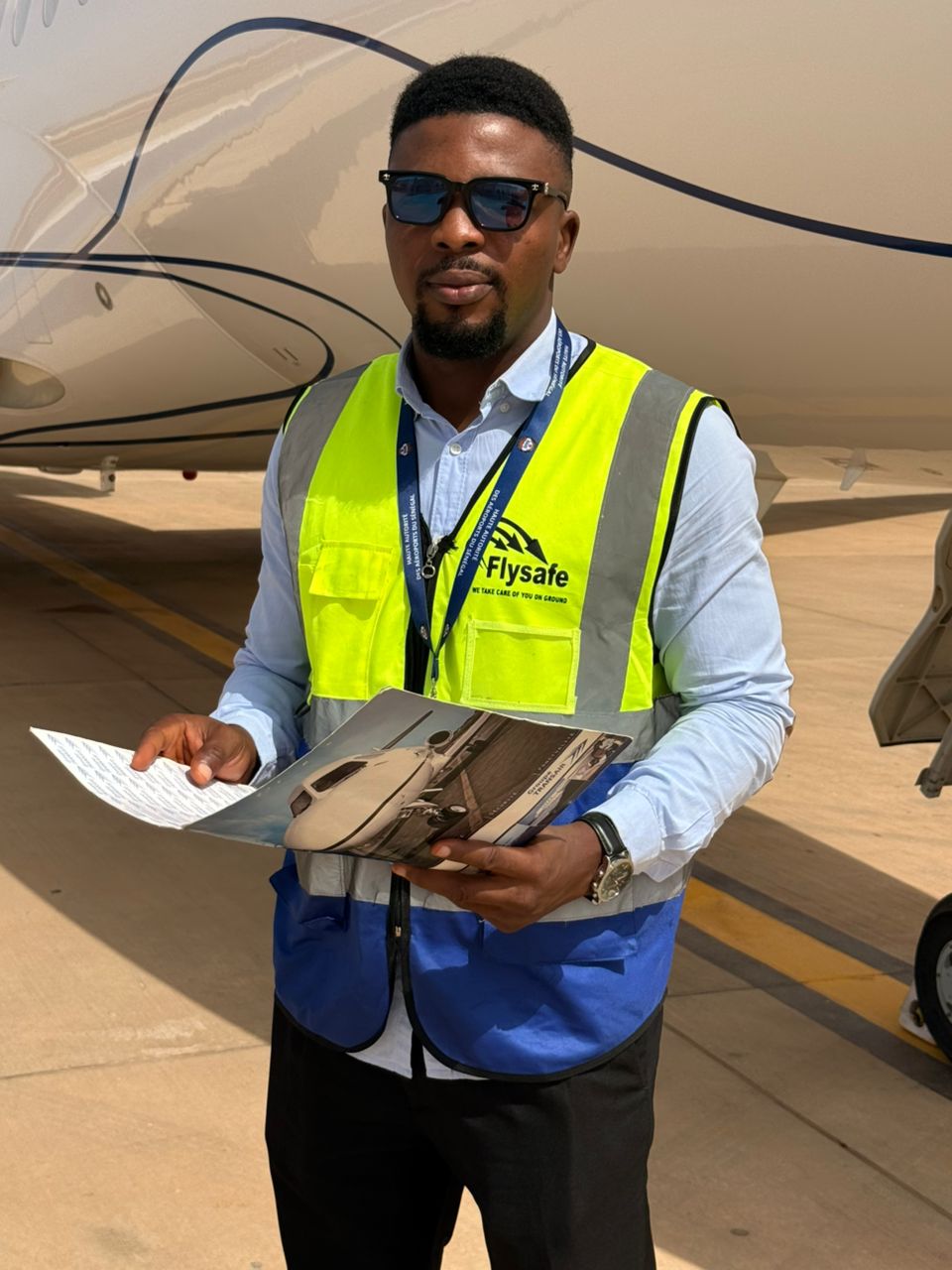 Flysafe ramp supervisor reviewing operational documents beside an aircraft